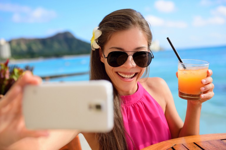 Slappe av med en selfie og juice på stranden