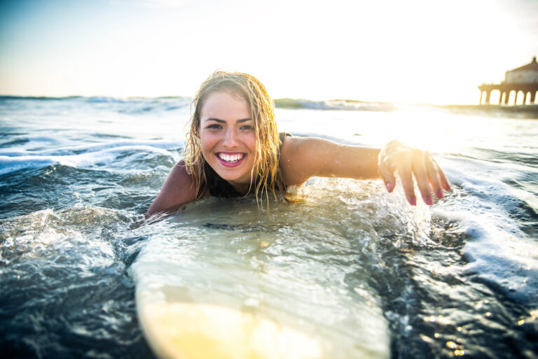 Fornøyd jente på surfbrett i Syden
