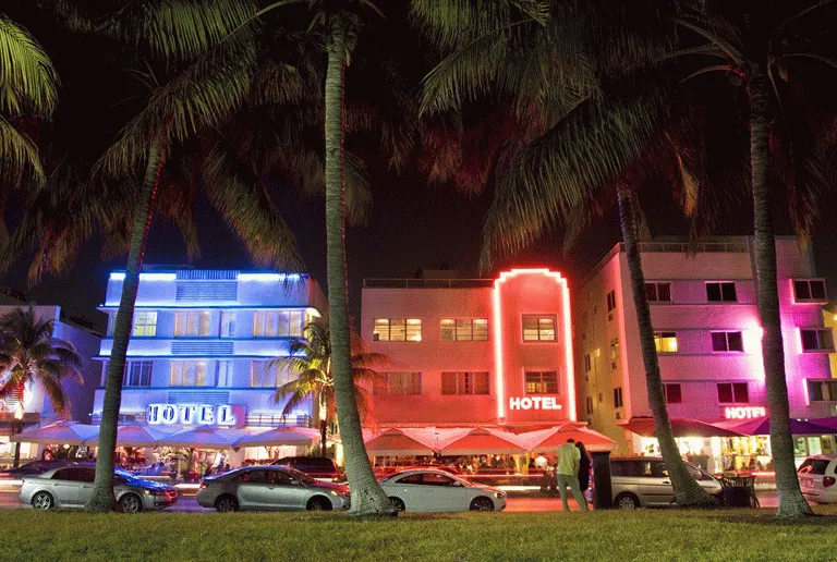 South Beach viser seg frem med neonlys og flotte biler på kveldstid 